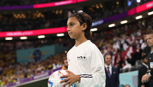 Niño recogebalones con uniforme Kia ingresando al estadio